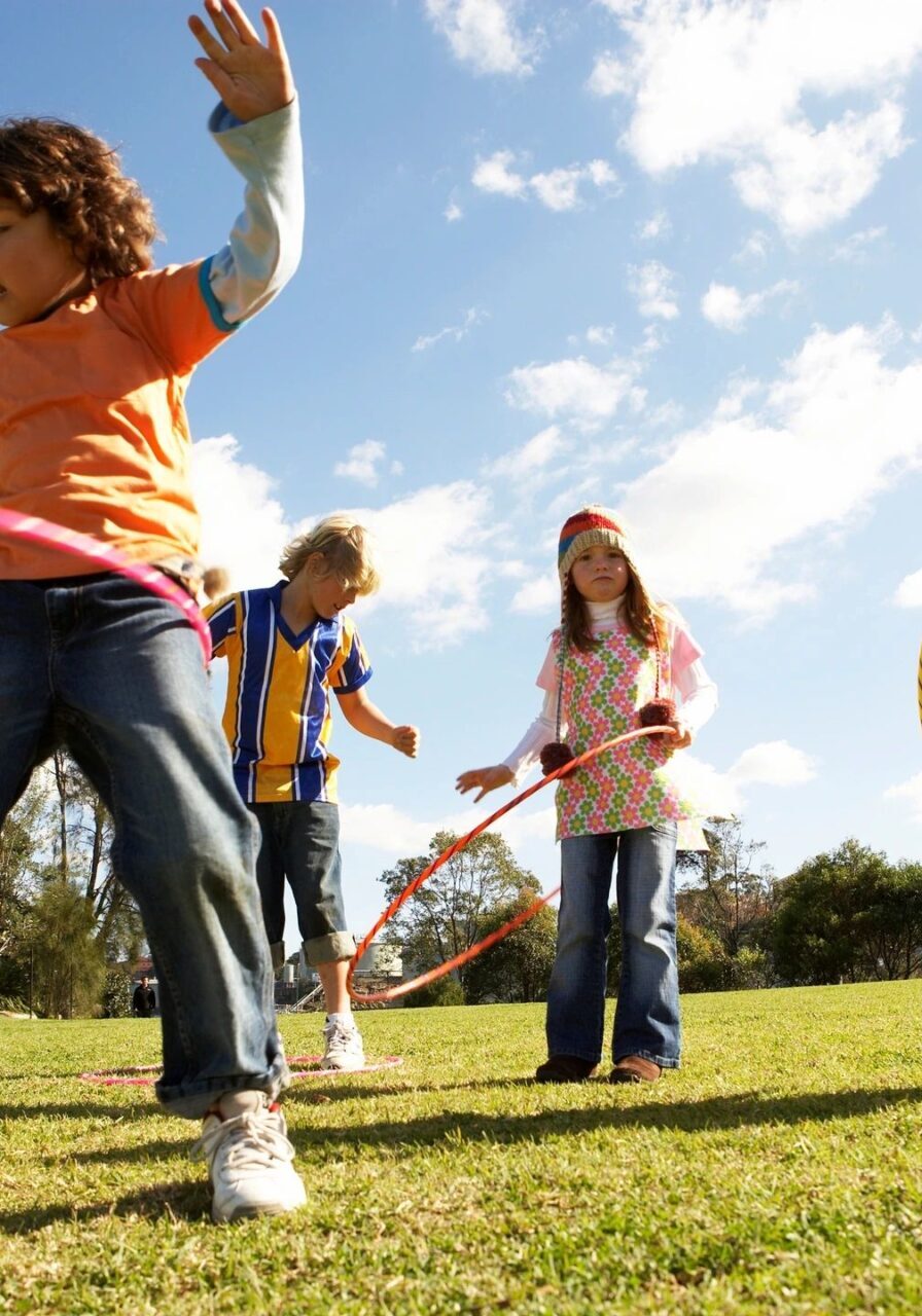 A group of children playing with hula hoops.